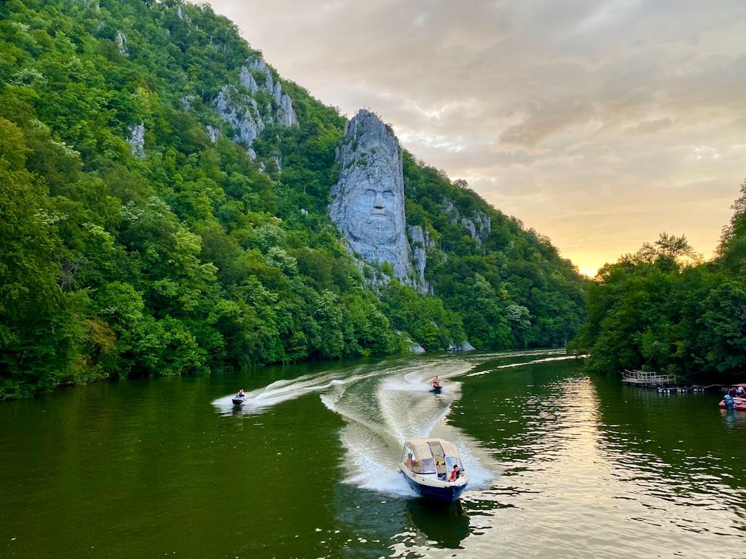 A riverboat cruising past the historic blue tower of Dürnstein under a clear summer sky