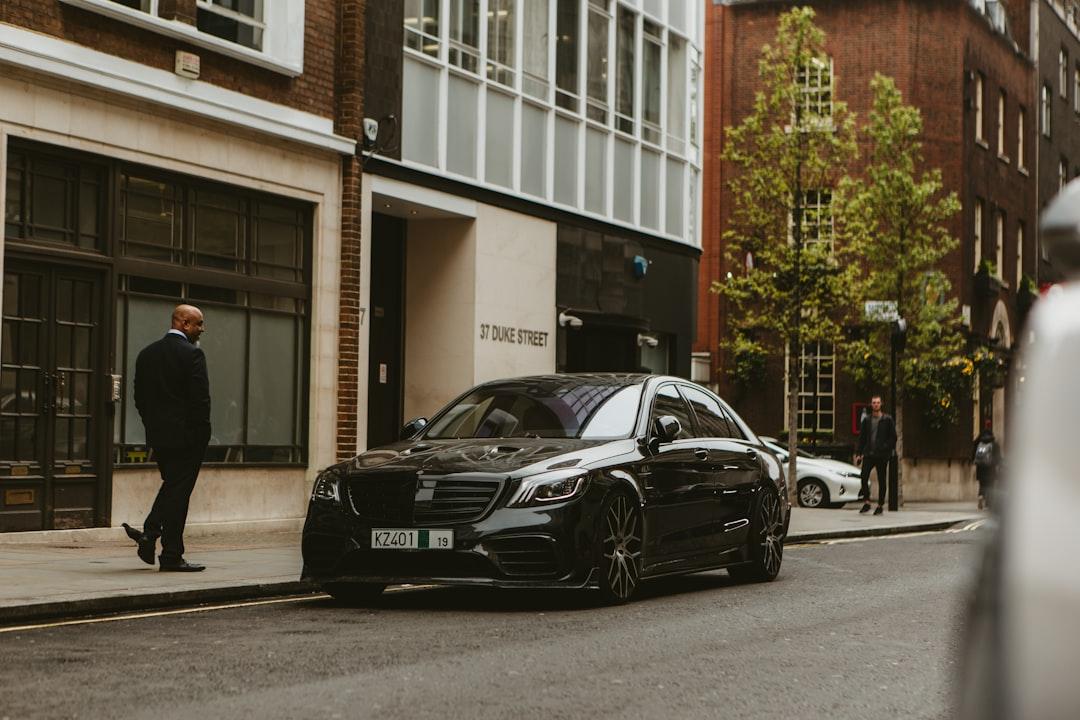 chauffeur waiting professionally outside a corporate building for a business meeting client